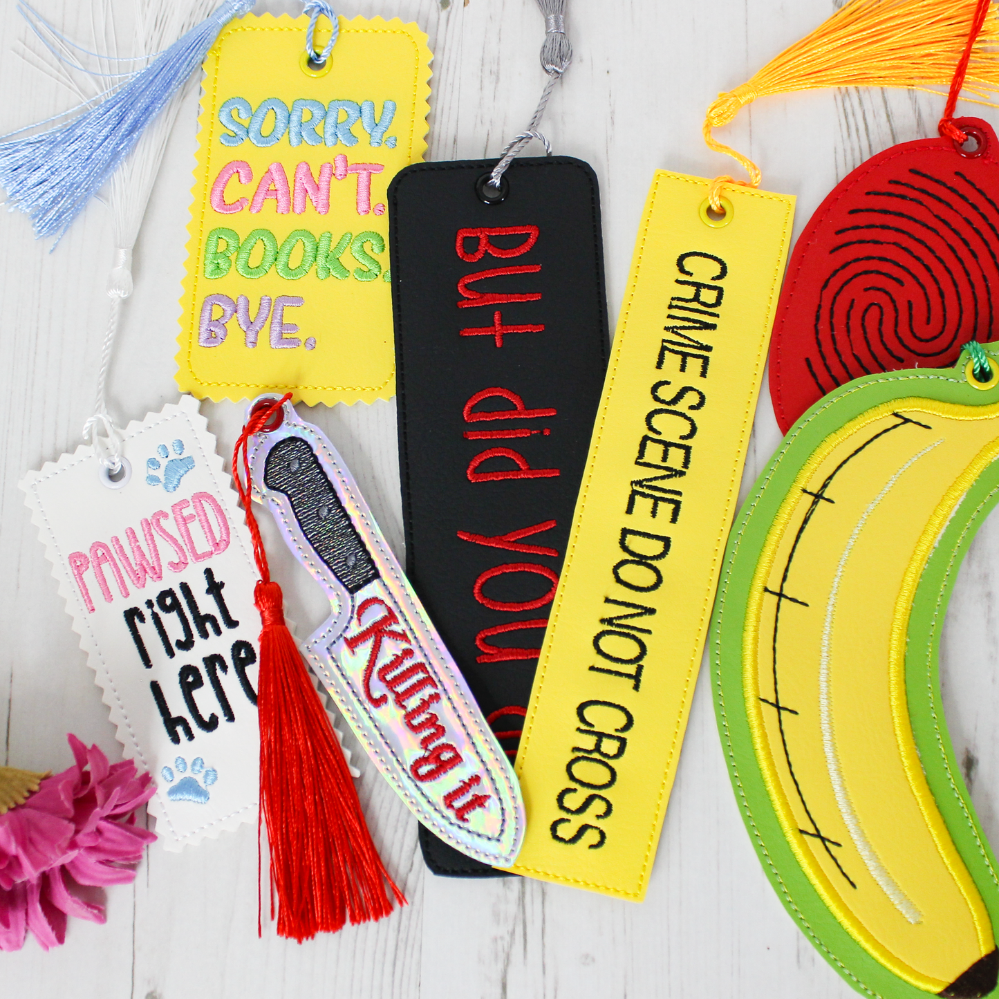 Colorful bookmarks with unique designs and text on a wooden surface.