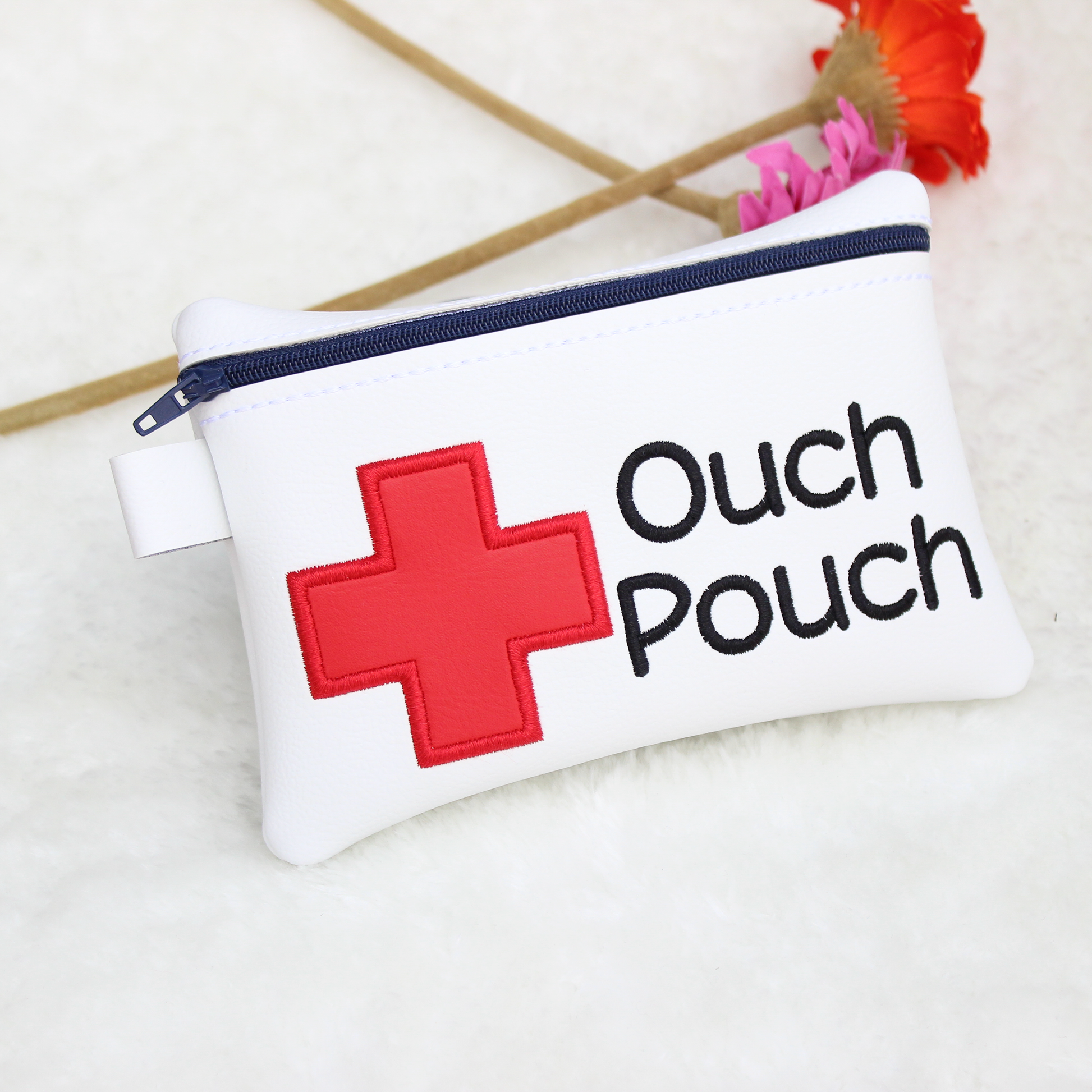 White pouch with red cross and 'Ouch Pouch' text on a light background