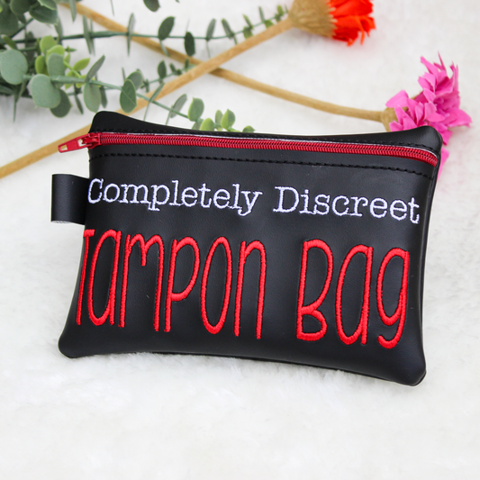 Black tampon bag with red and white completely discreet tampon bag text on a light background with flowers.